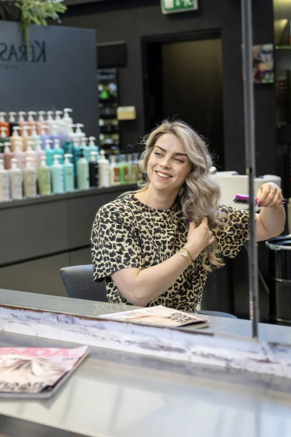 Roseanne in de spiegel van de salon, borstelt haar haar